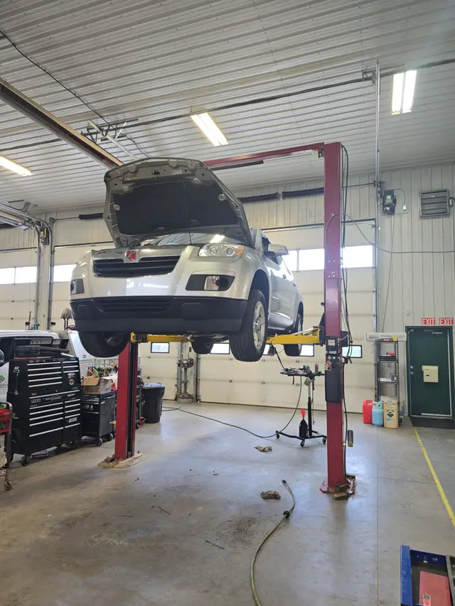 SUV raised on a two-post lift in the Rocky Mobile shop